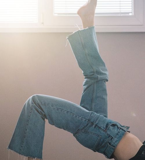 Silhouette of a person in a peaceful stretching pose against a window.